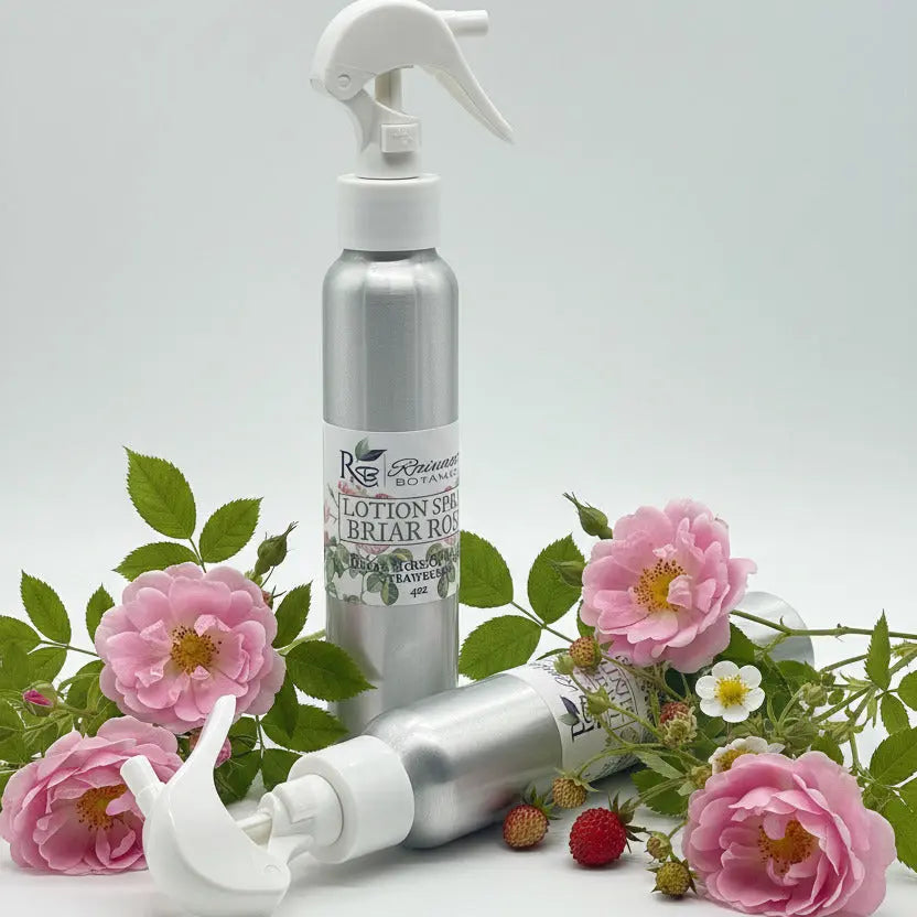 Two silver spray bottles with white nozzles on a light gray background