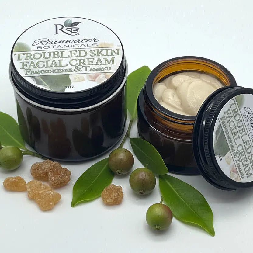 Open jar of Rainwater Botanicals Troubled Skin Facial Cream on a white background