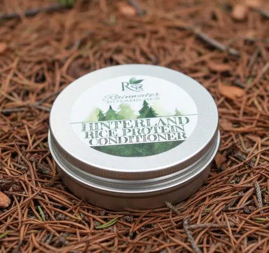 Hinterland Rice Protein Conditioner container with Rainwater Botanicals branding on a green leaf background
