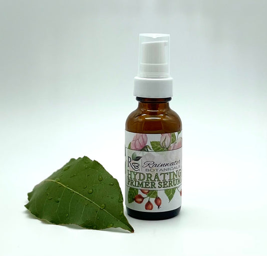 Bottle of Rainwater Botanicals Hydrating Primer Serum with a green leaf on a white background