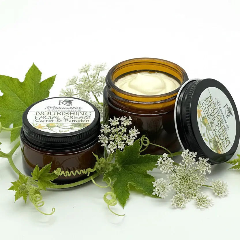 Two open jars of nourishing facial cream with visible cream inside on a white background.