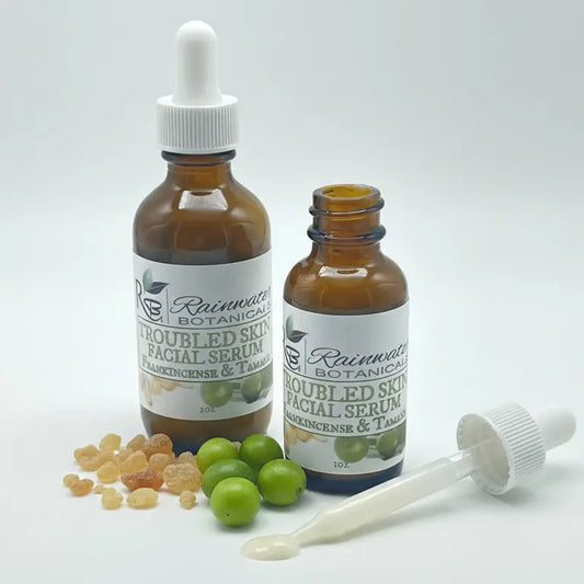Two bottles of Rainwater Botanicals Troubled Skin Facial Serum with droppers on a white background.